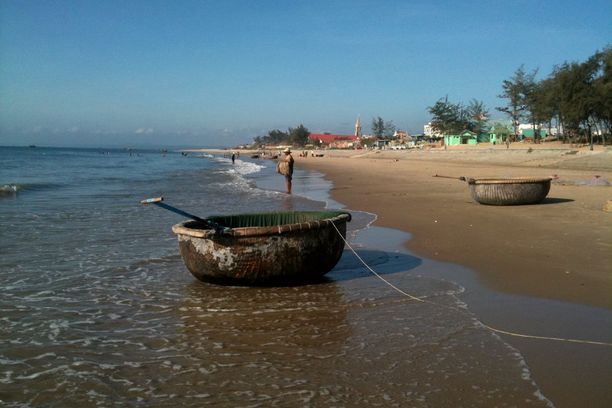 Chiếc thuyền thúng neo bên mép nước trên bãi biển Phan Thiết
